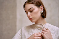 a woman wearing a white quilted jacket and ring