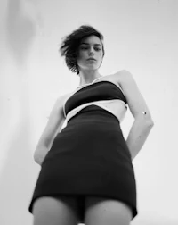 a black and white photo of a woman in a short dress